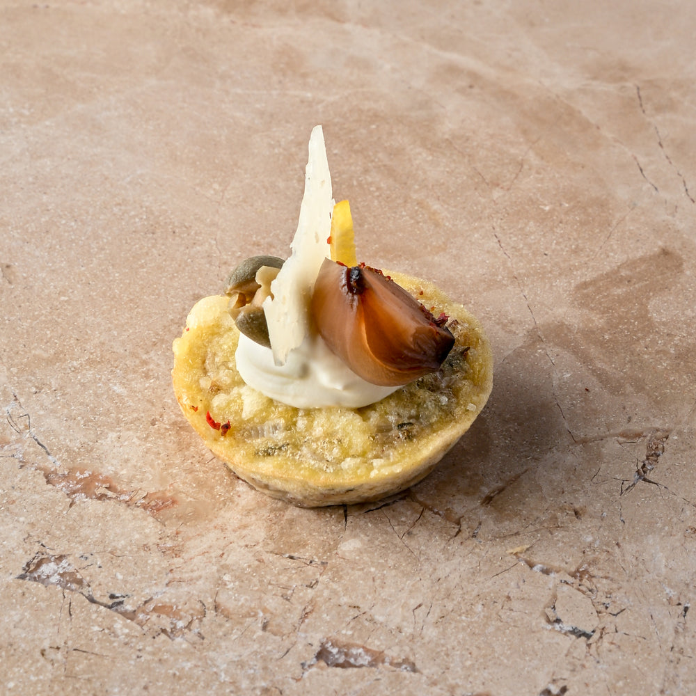 Cheddar and sauté onion frittata, aged Manchego, caper, balsamic shallot, zest, lemon crème (GF)