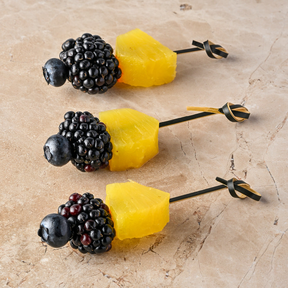 Compressed pineapple, blackberry, blueberry skewer