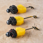 Compressed pineapple, blackberry, blueberry skewer