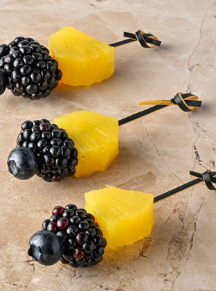 Compressed pineapple, blackberry, blueberry skewer