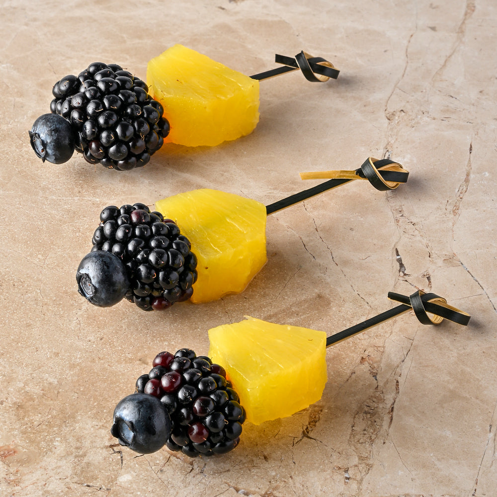 Compressed pineapple, blackberry, blueberry skewer