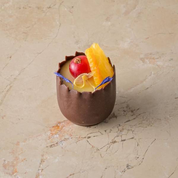 Orange cardamom posset, chocolate cup, red current, fresh orange, zest img